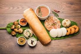 South Indian breakfast spread on banana leaf: dosa, idli, vada, sambar, and chutneys